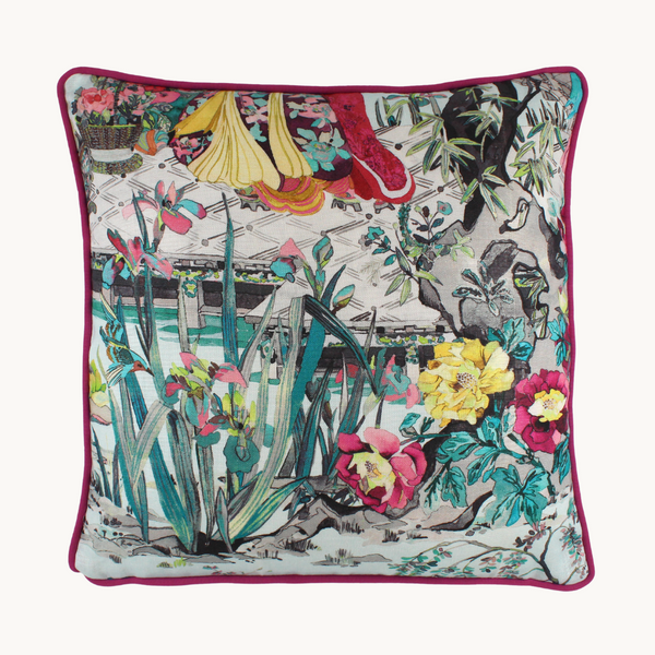 Photo of a colourful linen cushion with a mint coloured background and a Japanese garden scene with pinks, coral and yellow 