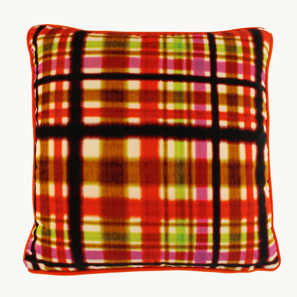 Photo of a square cushion in a very bright plaid design; oranges, pinks, lime green and licorice.