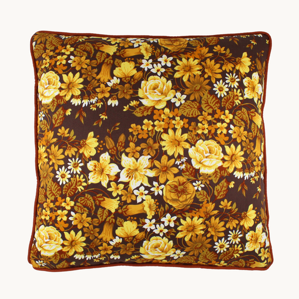 Photo of a 1970s inspired medium scale floral in bright yellow and ochre with a chocolate brown background