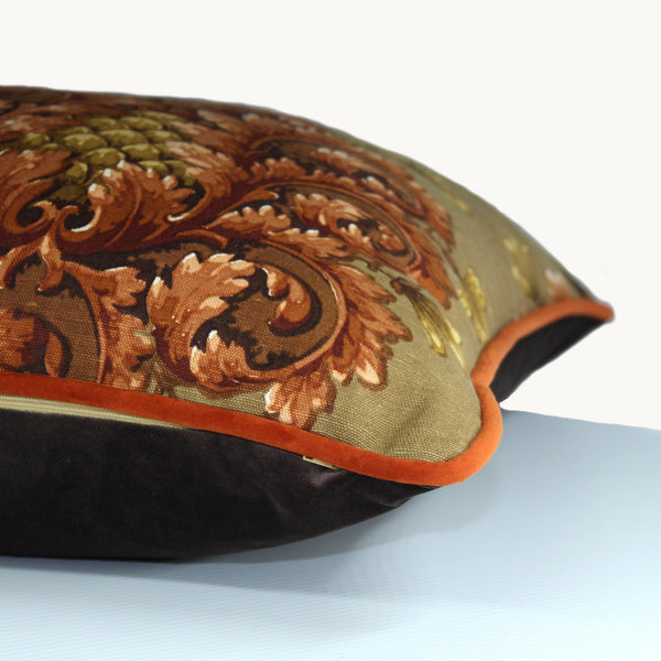 Side shot of a square cushion with a khaki background and baroque scrolled motifs in a chestnut colour