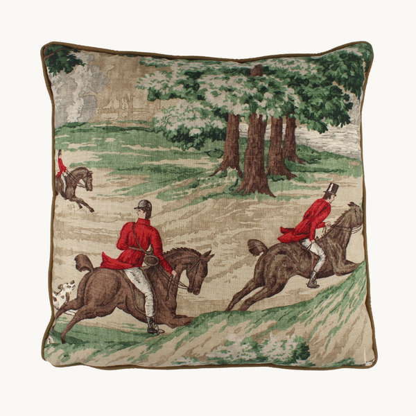 Photo of a linen cushion with a classic English hunting scene of horses and riders and hounds in green, red, brown and taupe