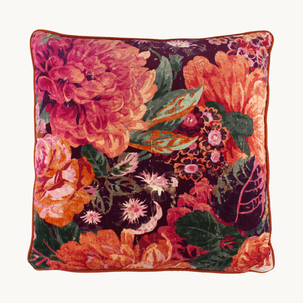 Photo of a vibrant velvet floral cushion in plum, hot pink, aubergine, orange and green