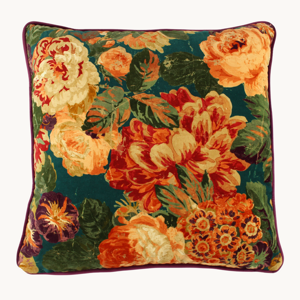 Vibrant velvet floral cushion in orange, rust, teal, aubergine and peach.