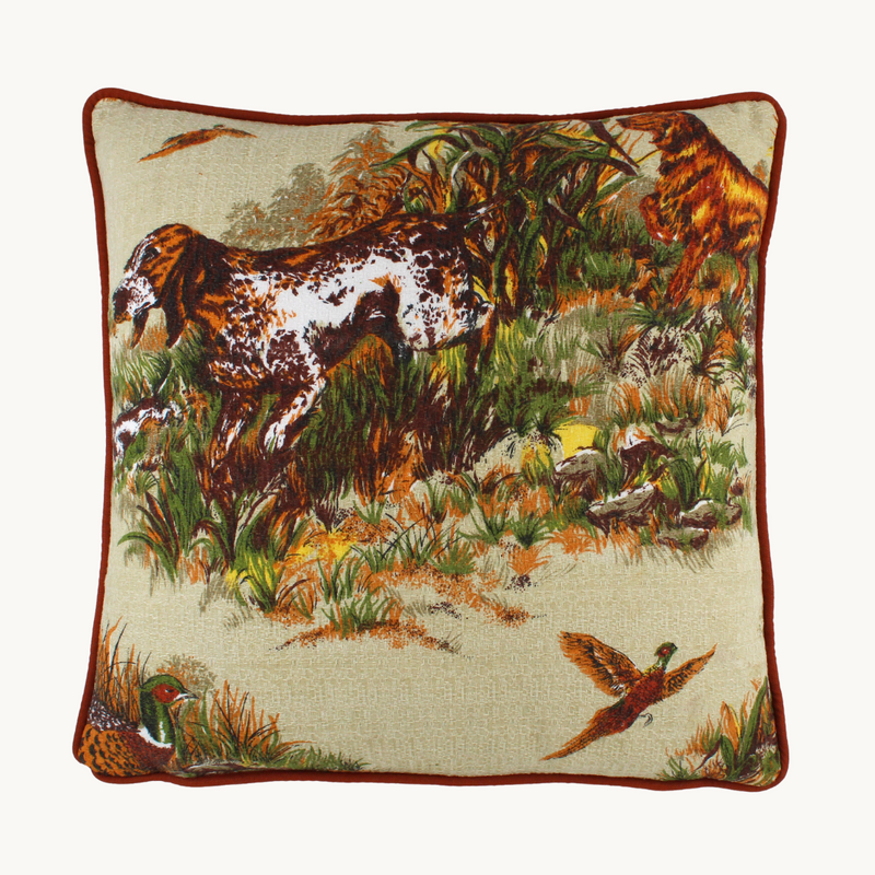 Photo of a cushion in a vintage barkcloth showing setter dogs and pheasants in an autumn colour palette