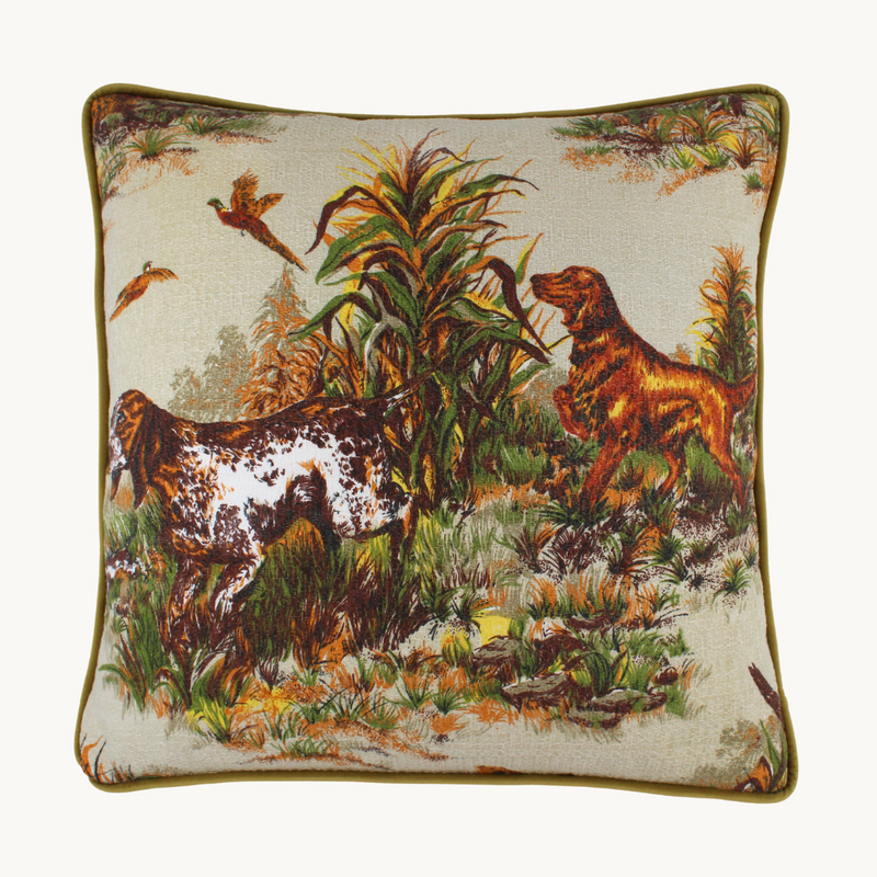 Photo of a cushion in a vintage barkcloth showing setter dogs and pheasants in an autumn colour palette