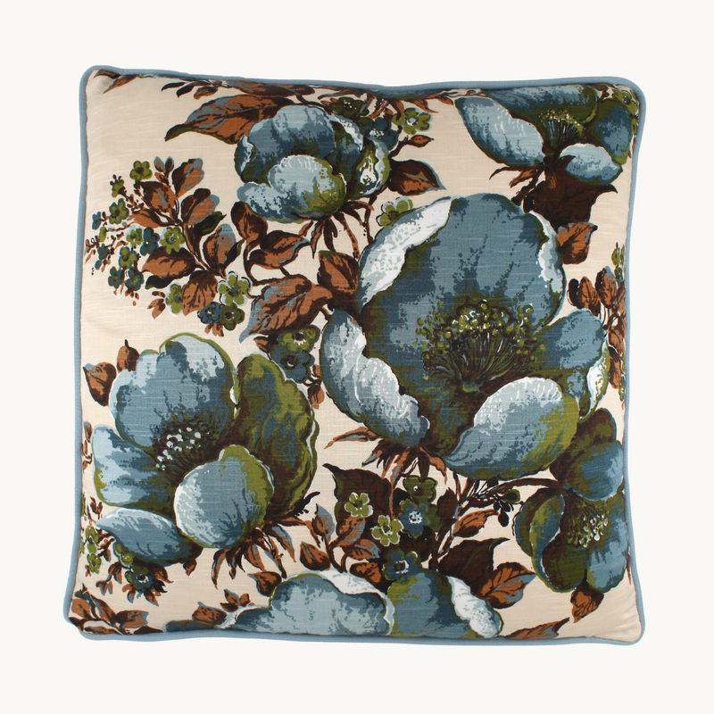 Photo of a cushion made from a vintage fabric with large scale flowers in slate blue with touches of olive and cinnamon