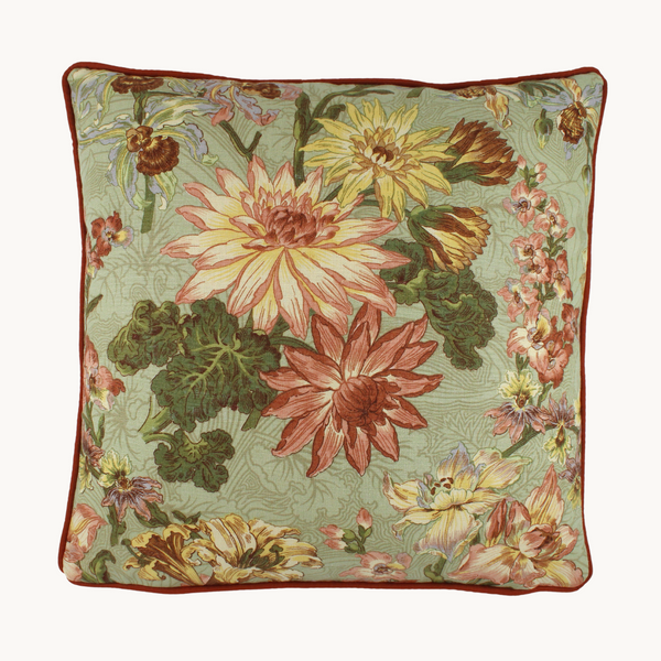 Photo of a cushion made from a vintage linen in a floral design with a sage green background and dahlias in pinks and soft rust with hints of lilac