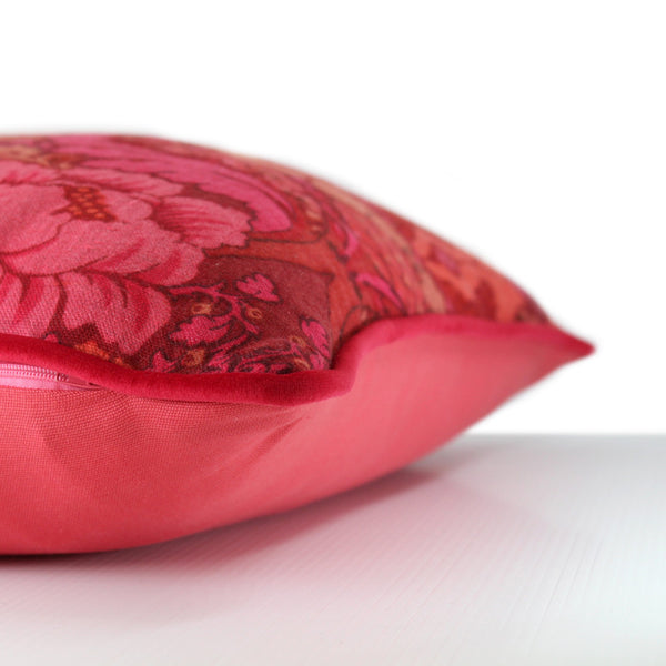 Side view of a cushion made from a punchy vintage damask in hot pink, coral and red